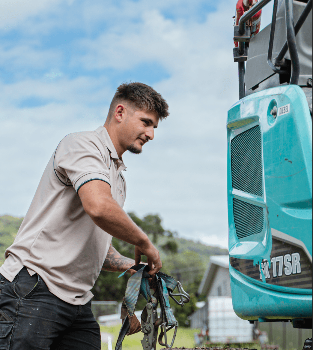 VTRAX operator securing the Kobelco SK17SR for transport